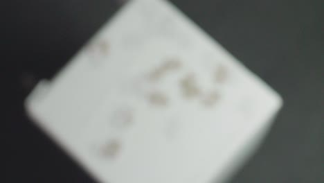 white and gray puzzle pieces falling on a white surface and bouncing and spinning back with a dark background tracking shot