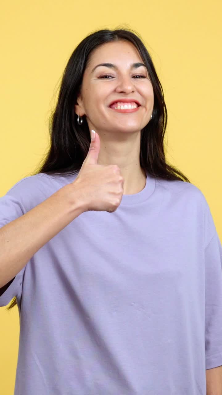 Happy young woman smiling and giving a thumbs up