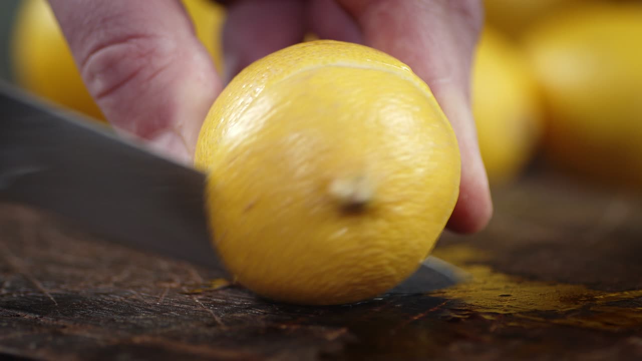 Men's hands cut juicy lemon on the cutting Board.