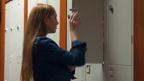 student gathering her school books from a locker