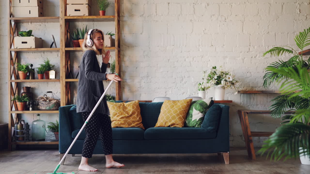 Woman Cleaning and Dancing to Music in Living Room