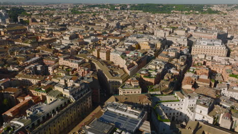 Forwards-fly-above-historic-town-development-in-city-centre.-Old-buildings-and-tourist-landmarks-in-morning-sunshine.-Rome,-Italy