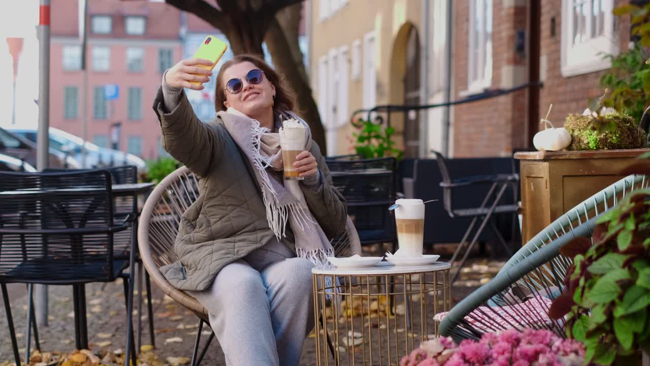 Woman taking a selfie at a cafe in autumn