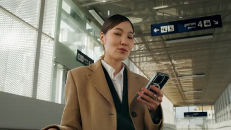 businesswoman using smartphone at train station