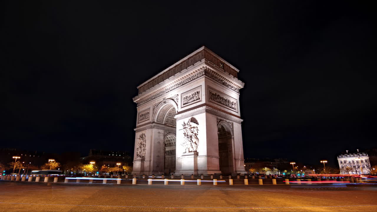 Hyperlapse del monumento Arco di Trionfo a Parigi, Francia, con traffico intenso di notte e scie luminose di automobili.