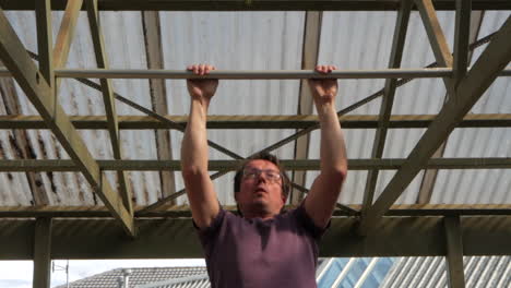 middle aged man doing chin ups