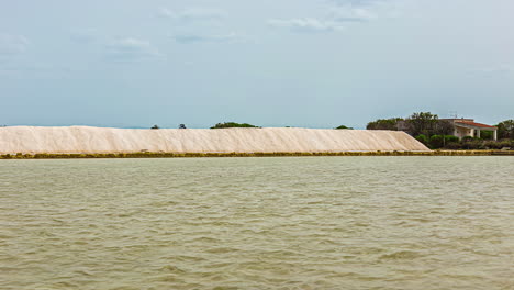 timelapse shot of the salt pile after making in nubia, near the city of trapani in sicily while torre saracena in the background on the egadi islands