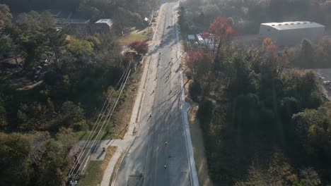 Inclinación-Aérea-De-Drones-De-Ciclistas-Con-Construcción-De-Carreteras