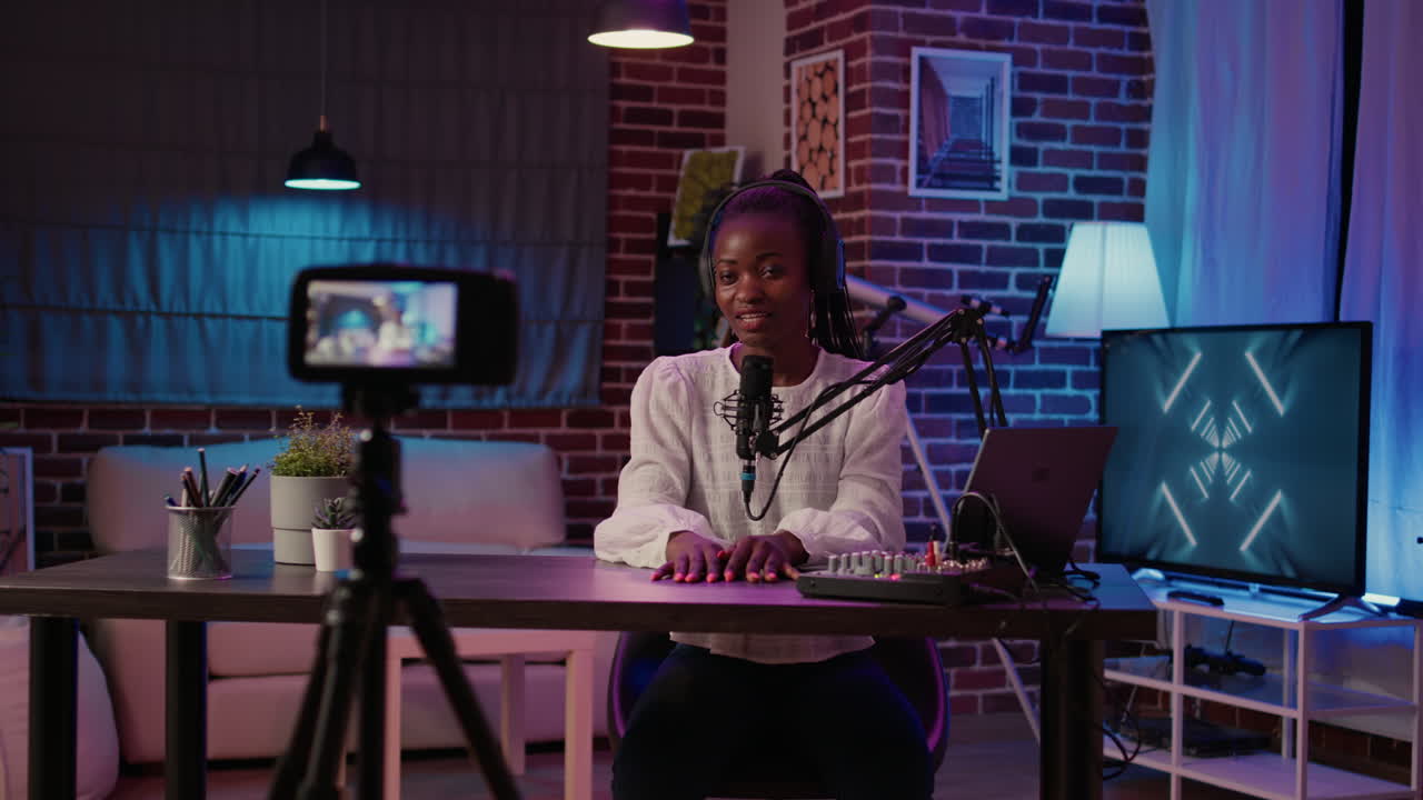 African american woman internet radio host recording live broadcast using digital video camera