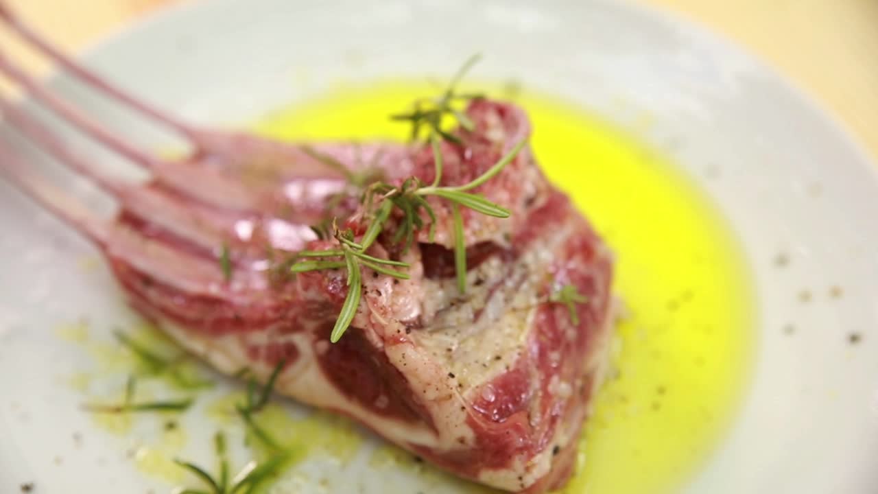 preparando chuletas de cordero con romero y aceite