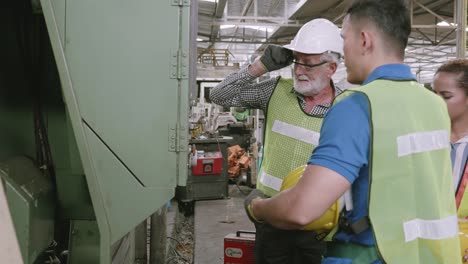 group of engineer talking and training working using machine control together in industrial factory, foreman discussing and teaching trainee, people diversity, indoors, industry concept.