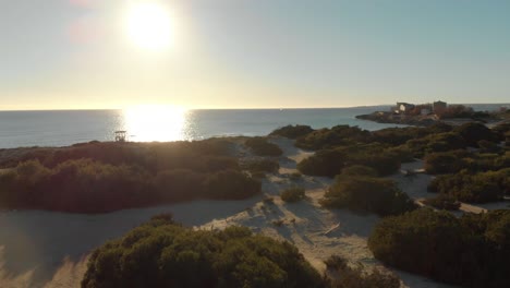 sunset over a mediterranean coastline with sand dunes