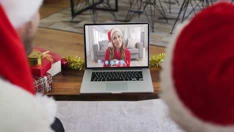 Caucasian-couple-having-a-christmas-video-call-with-family