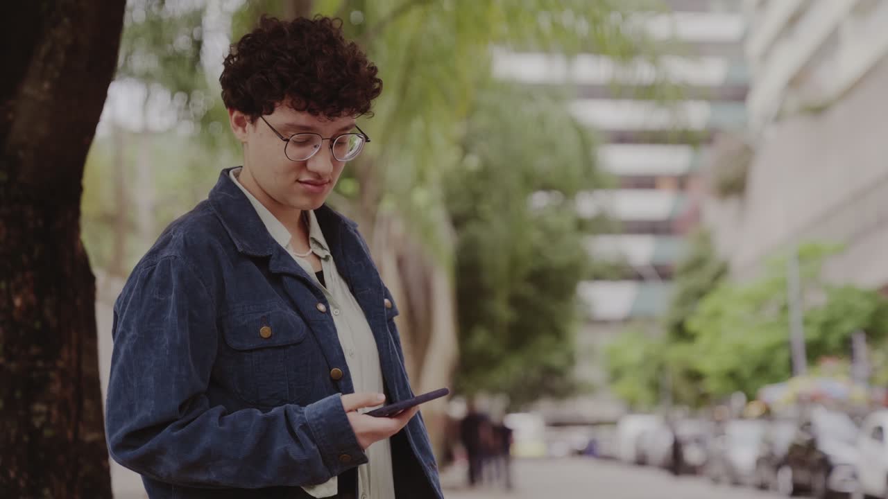 Young person using a smartphone outdoors in a city