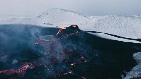 Steam-rises-from-lava-field-on-dark-surface-in-remote-Iceland-landscape,-aerial