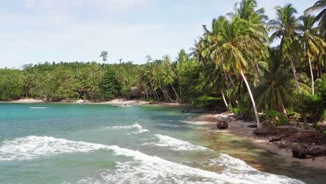 Aerial-backwards-flight-along-turquoise-Indonesian-palm-beach-with-boats