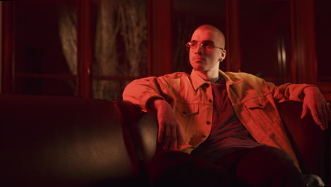 man seated in red light