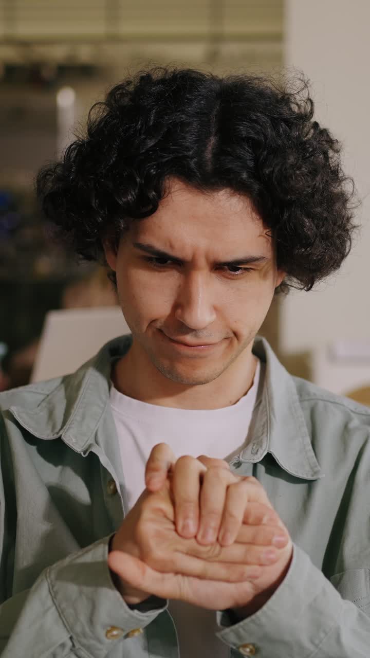 Young Man with Curly Hair Focused and Contemplating