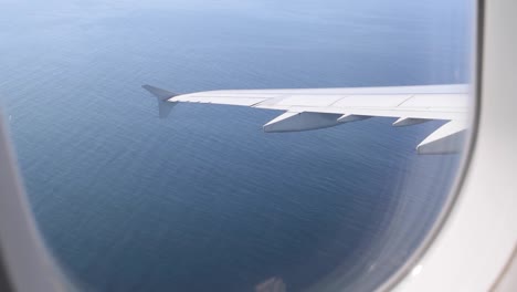 Vista-Panorámica-Desde-El-Interior-De-Un-Avión-Que-Vuela-A-Un-Destino-Sobre-El-Océano-Mientras-Gira