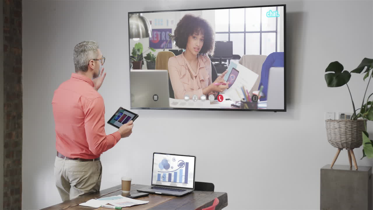 Caucasian businessman on video call with african american female colleague on tv screen