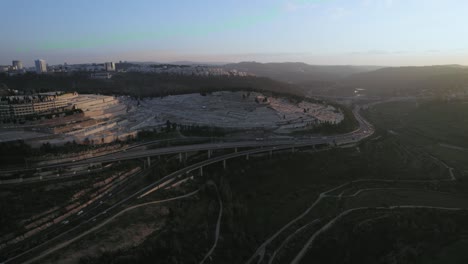 Zurückziehende-Aufnahme-Des-Sonnenuntergangs-über-Einer-Wald--Und-Autobahn-Eisenbahnbrücke