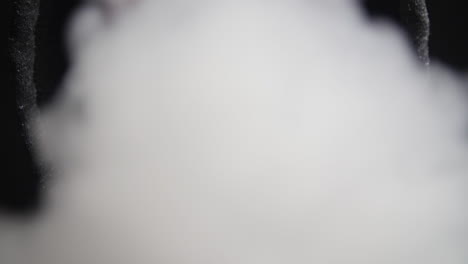 hombre encapuchado exhala vapor en la cámara