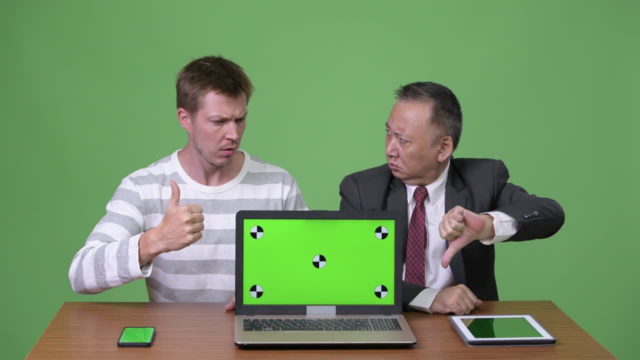 성숙한 일본 사업가와 젊은 스칸디나비아 사업가가 함께 일하고 있습니다.