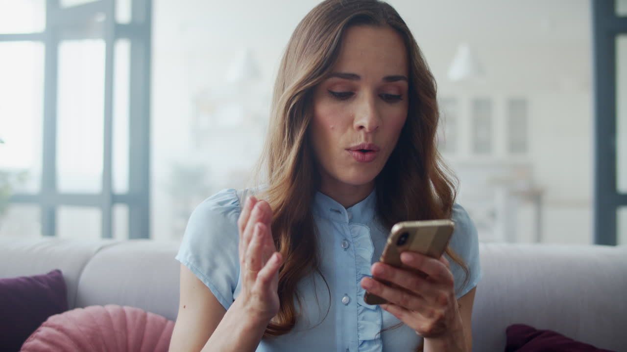 Mulher de negócios lendo boas notícias no telefone no sofá. Garota conversando ao telefone.
