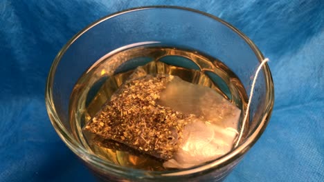 a tea bag is brewed in a glass.