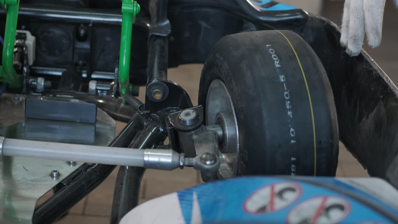 el mecánico del servicio de carreras de go kart cambia las ruedas