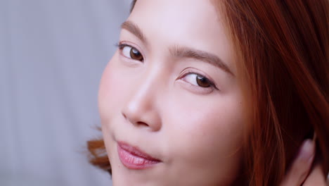 Cheerful-good-looking-young-redhead-woman-with-freckles-in-the-apartment-looks-at-the-camera-and-smiles-sincerely