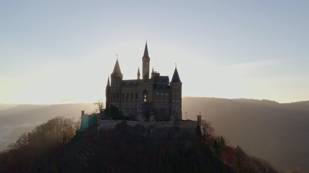 Východ slunce vrhá zlaté světlo na hrad Burg Hohenzollern na podzim, Německo