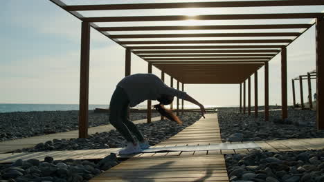 woman practicing yoga on a beach