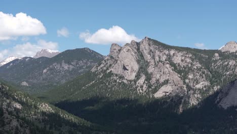 aerial view, hills and peaks of rocky mountains on sunny summer day, drone shot