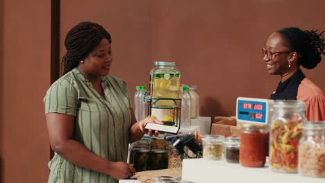 african american woman paying with mobile nfc at pos