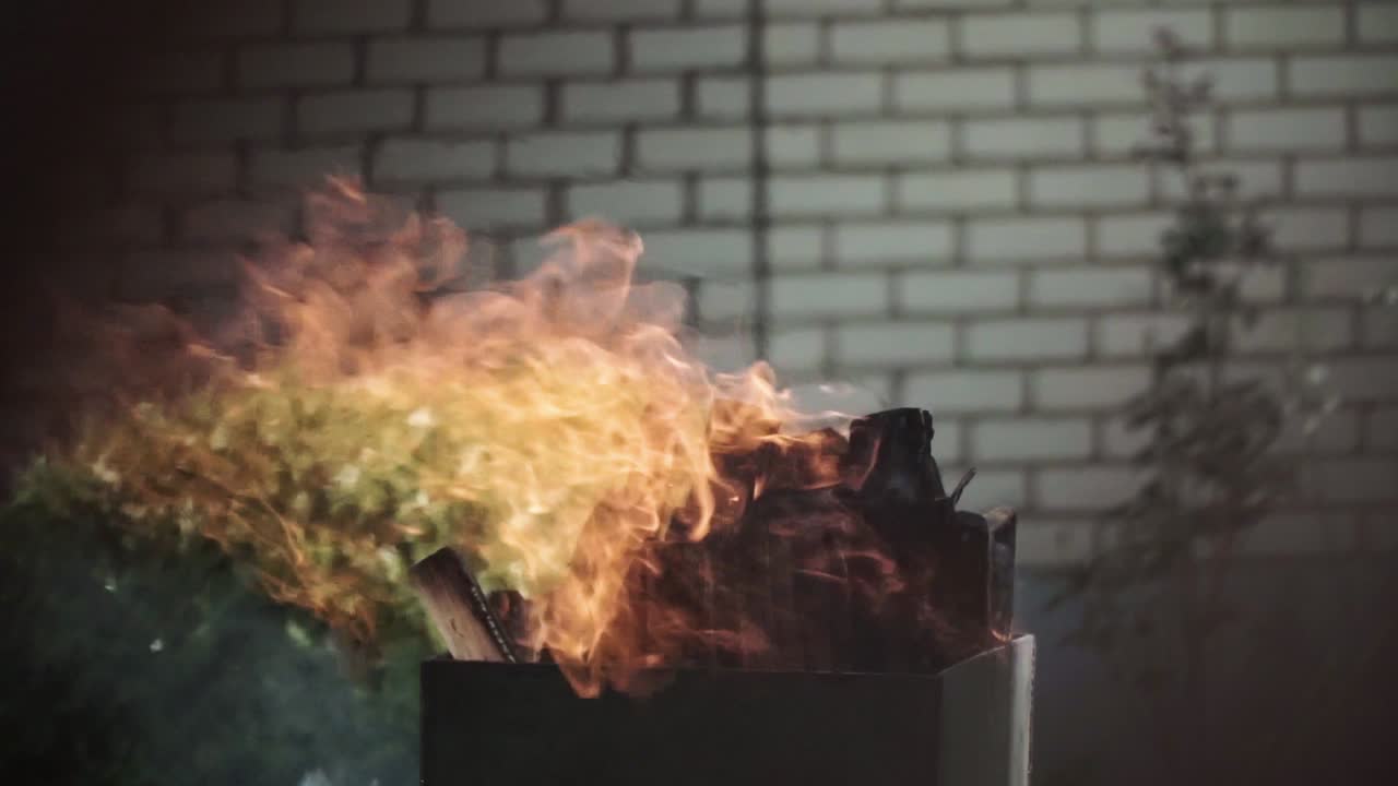 검은 금속 벽난로에서 나무가 불타고 있다