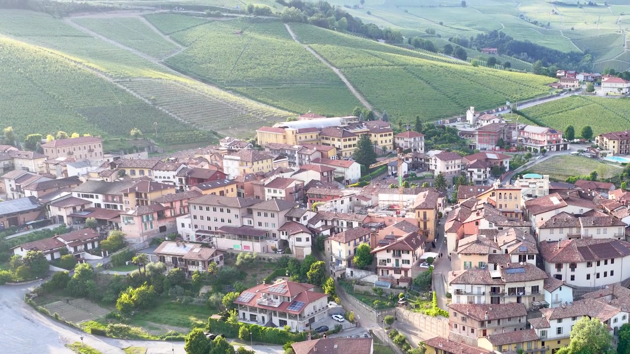 Droneoptagelser viser den historiske landsby Barolo omgivet af bølgende grønne vinbakker.
