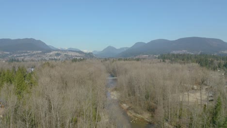 suburban landscape with river and view of the mountains in the background. above river bed.