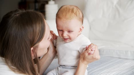 joyful mom communicating with adorable baby daughter