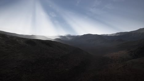 sun rays over mountains in a valley