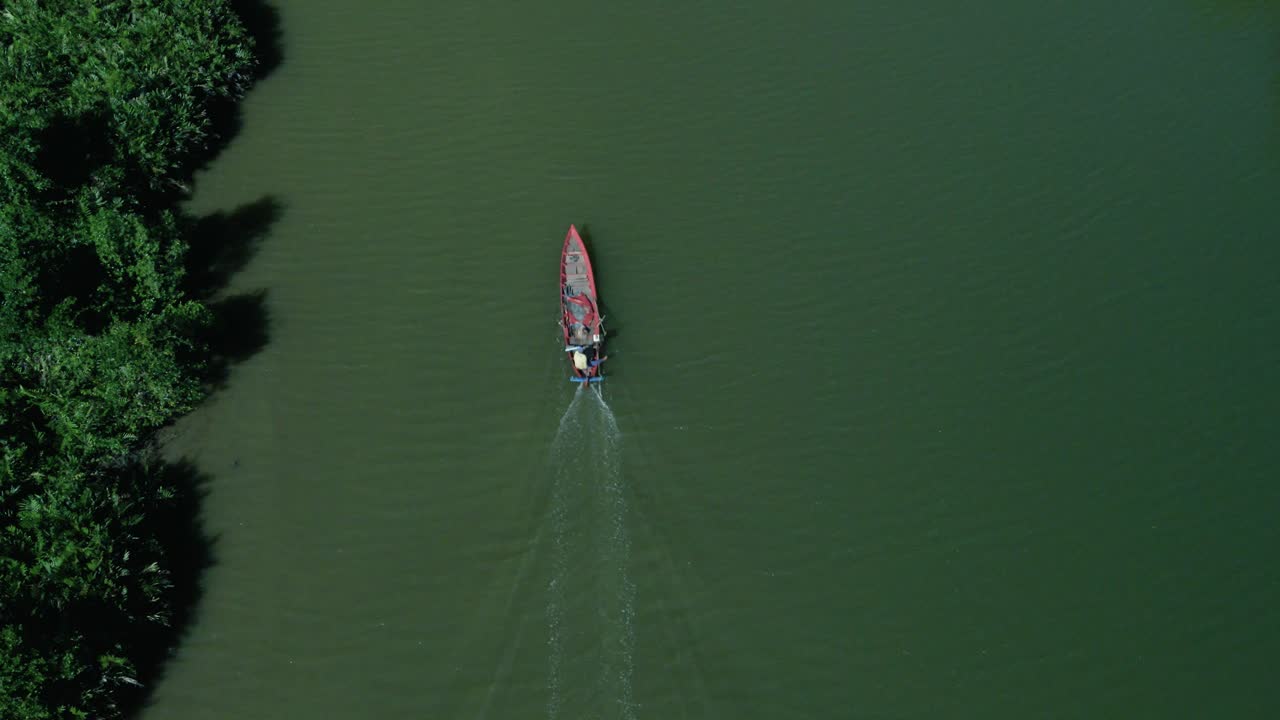 sencillo barco pesquero asiático que viaja a lo largo de la limpia costa de manglares verde esmeralda, vista aérea de drones, espacio para copiar