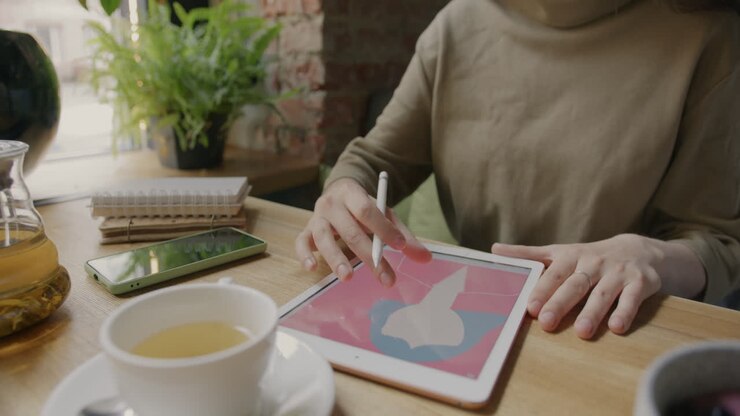 Donna che progetta su tablet al bar