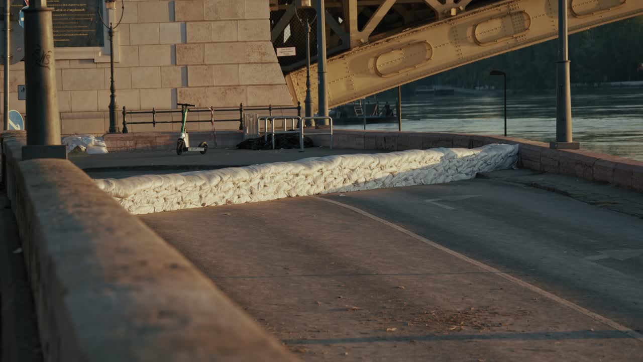 Sandbags block a flooded road under a bridge near the riverbank, Budapest, Hungary