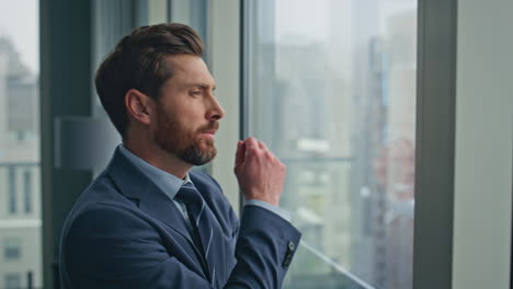 thoughtful businessman standing panoramic window alone closeup. boss pondering