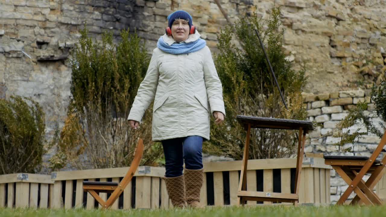 즐거운 할머니는 헤드폰으로 음악을 듣습니다.