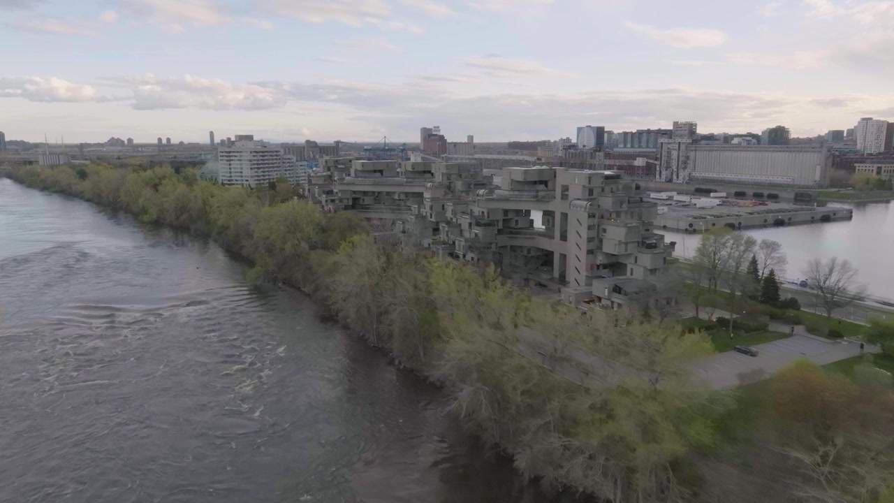 Drone che sorvola il fiume San Lorenzo, mostrando l'edificio Habitat 67 e la città di Montreal sullo sfondo, in Quebec, Canada.