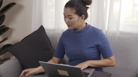 asian businesswoman authentic shot using a laptop to work from home happily