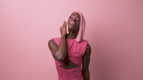 black muscular transgender cosplaying doll in pink wear on pink background