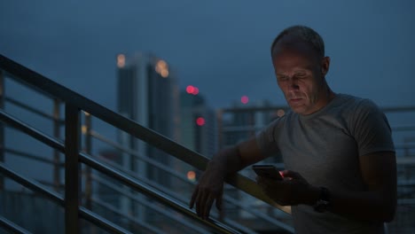 mature scandinavian man thinking while using phone against view of the city