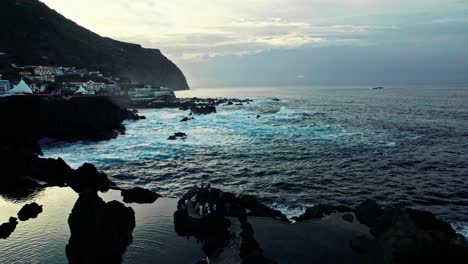 coastal scene with pools and town at sunset